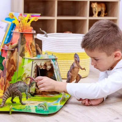 Enfant jouant avec des figurines dans le décor La terre des dinosaures Papo 60600