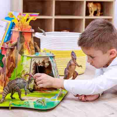 Enfant jouant avec des figurines dans le décor La terre des dinosaures Papo 60600