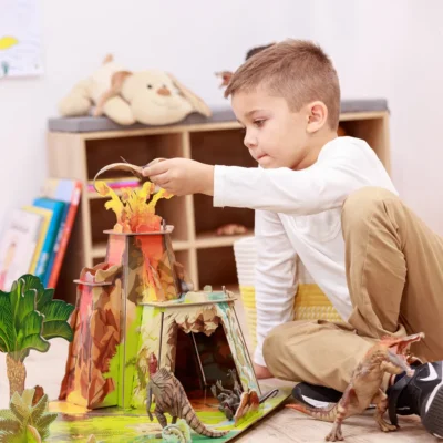 Enfant jouant autour du volcan du décor La terre des dinosaures Papo 60600