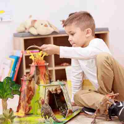 Enfant jouant autour du volcan du décor La terre des dinosaures Papo 60600
