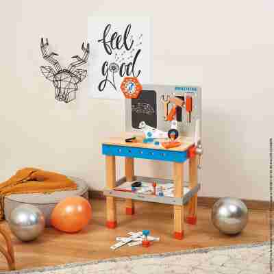 Établi Brico'Kids Janod installé dans une chambre avec outils et pièces de construction
