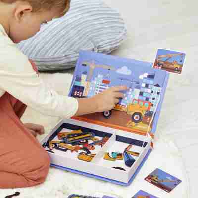 Enfant assemblant un engin sur le décor de chantier du Magnéti'book Janod