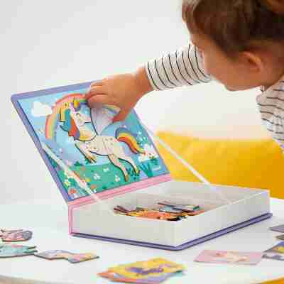 Enfant assemblant une licorne sur le décor magnétique du Magnéti'book Janod