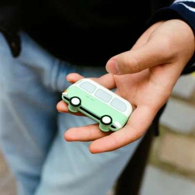 Money Walkie en forme de van vert présenté dans une main